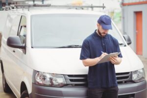 Un acheteur examine un utilitaire d’occasion sur un parking avant de l’acheter.